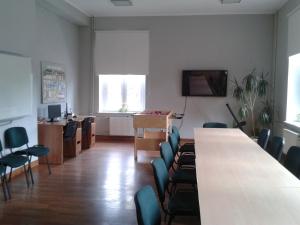 Una habitación con una mesa y sillas y un televisor. en Szkolne Schronisko Młodzieżowe w Gdańsku, en Gdansk