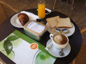 einen Tisch mit einer Tasse Kaffee und einem Teller Essen in der Unterkunft Hi Valencia Canovas in Valencia