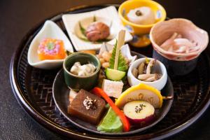 a black plate of food with different types of food at Fumoto Ryokan in Minamioguni