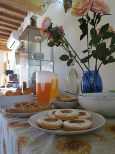 a table with plates of cookies and glasses of orange juice at Fondo Riso in Faenza