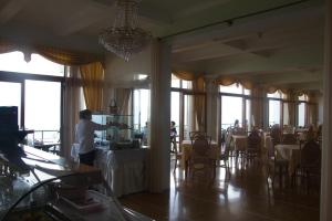 a man standing in a room with a table in a restaurant at Hotel Il Nido Sorrento in Sorrento