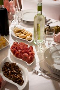 a table with plates of food and a bottle of wine at Agriturismo Menhir in Villagrande Strisaili