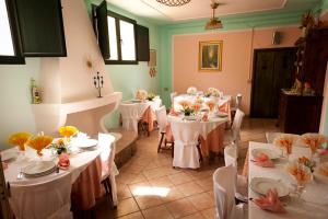 Una habitación con mesas y sillas blancas con flores. en Agriturismo Menhir, en Villagrande Strisaili 43 fotos más