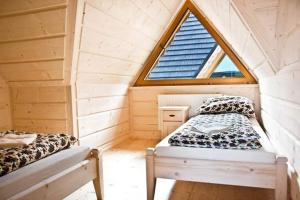 a bedroom with two beds in a wooden cabin at Domki pod lasem in Nowe Bystre