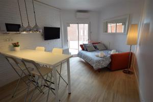 ein Wohnzimmer mit einem Tisch und einem Sofa in der Unterkunft Apartamento Playa Mar in Castelldefels