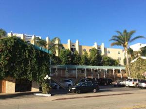 ein großes Gebäude mit Autos auf einem Parkplatz in der Unterkunft 777 Motor Inn in Sherman Oaks