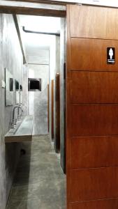 ein Badezimmer mit Holztür und Waschbecken in der Unterkunft Dayon Hostel in Coron