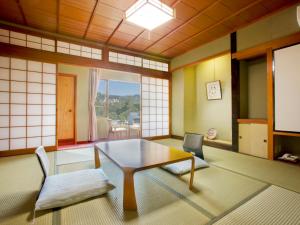 a living room with a table and two chairs at Hoseikan in Matsue