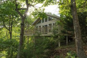 a house with a deck in the woods at Beaver Lake Cottages in Eureka Springs