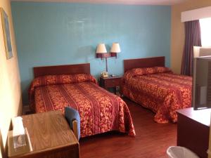 Habitación de hotel con 2 camas y mesa en Ole English Inn, en Tuscaloosa