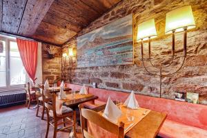 ein Restaurant mit Holztischen und -stühlen und einer Steinmauer in der Unterkunft Hotel Restaurant Resslirytti in Basel