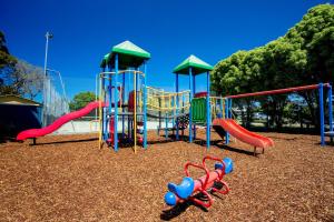 - une aire de jeux avec des toboggans colorés et un bureau dans l'établissement BIG4 Whiters Holiday Village, à Lakes Entrance