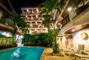 a hotel with a swimming pool in front of a building at Aonang Sunset Hotel - SHA Extra Plus in Ao Nang Beach