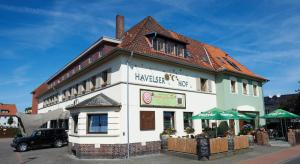 a large white building with a red roof at Hotel Havelser Hof in Garbsen