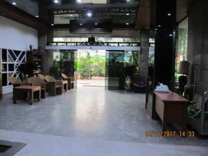 eine Eingangshalle mit Stühlen und Tischen in der Unterkunft Tongpoon Hotel in Bangkok
