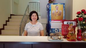 una mujer sentada en un mostrador con un plato de comida en Baan Taweesuk Guest House en Hua Hin