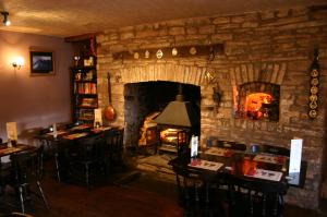 a living room with a stone fireplace with a table and chairs at The Tanners Arms in Devynock