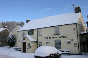 a inn covered in snow with a car parked in front at The Tanners Arms in Devynock