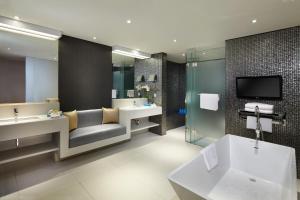 a bathroom with two sinks and a tv on the wall at Double - Six, Luxury Hotel - Seminyak in Seminyak