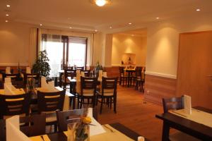 a dining room with tables and chairs in a restaurant at Landhotel Oßwald in Kirchheim am Ries