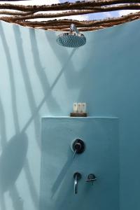 a bathroom with a blue wall with a sink at Bakwa Lodge in Rodrigues Island