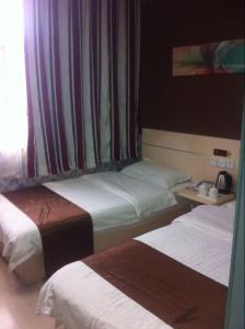 um quarto de hotel com duas camas e uma janela em Thank Inn Chain Hotel Fei Town Jianshe Road em Feixian