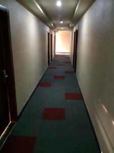 een hal met een lange gang met rood en groen tapijt bij JUNYI Hotel Jiangsu Nanjing University of Information Science and Technology in Nanjing