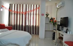 um quarto com uma cama, uma secretária e uma janela em Thank Inn Chain Hotel Fei Town Jianshe Road em Feixian