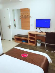 um quarto de hotel com uma cama e uma televisão em Thank Inn Plus Hotel Jiangsu Taizhou Taixing Jingjiang Primary School em Taixing