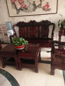 un sofá y una mesa con una maceta. en JUNYI Hotel Shandong Qingdao Huangdao District Shiyou University en Xianlang