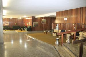 Fenícia Palace Hotel في باورو: غرفة بجدران خشبية وطاولات وكراسي
