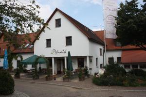 a white building with green umbrellas in front of it at Landhotel Oßwald in Kirchheim am Ries