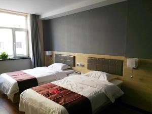 a hotel room with two beds and a window at Thank Inn Chain Hotel Inner Mongolia Tongliao Horqin Dis. Tienan Kundulun Ave in Tongliao