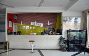 a woman sitting at a counter in a restaurant at Thank Inn Chain Hotel Fei Town Jianshe Road in Feixian