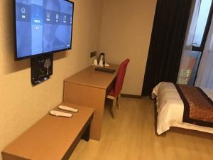 a hotel room with a bed and a flat screen tv at Thank Inn Chain Hotel Jiangsu Yancheng Dongtai Huiyin Plaza in Xintuan