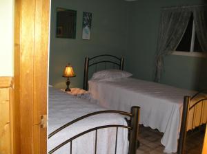 um quarto com duas camas e um candeeiro sobre uma mesa em Gulliver's Cove Oceanview Cottages em Centreville