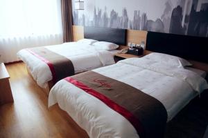 two beds in a hotel room with avertisement at Thank Inn Chain Hotel Jiangsu Zhenjiang Danyang Train Station in Jinglin +8 photos