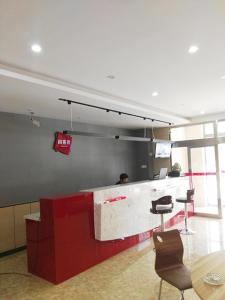 a lobby with a counter and chairs in a building at Thank Inn Chain Hotel Inner Mongolia Tongliao Horqin Dis. Tienan Kundulun Ave in Tongliao