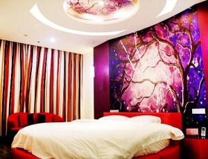 1 dormitorio con 1 cama y una pintura en la pared en Thank Inn Chain Hotel Jiangsu Nanjing Gaochun Market en Gaochun