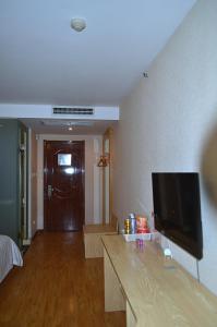 a living room with a flat screen tv on a wall at JUNYI Hotel Shandong Qingdao Huangdao District Shiyou University in Xianlang