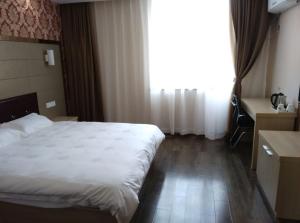 Cette chambre comprend un grand lit et une fenêtre. dans l'établissement JUNYI Hotel Jiangsu Suzhou Mudu Ancient Town, à Suzhou
