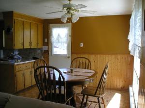 uma cozinha com uma mesa de jantar e cadeiras em Gulliver's Cove Oceanview Cottages em Centreville