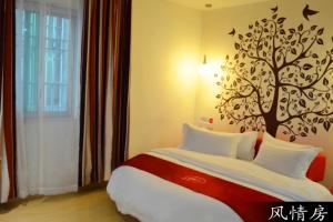 sypialnia z łóżkiem z drzewem na ścianie w obiekcie Thank Inn Chain Hotel Guangdong Guangzhou Hudu District Shiling Town Pangu Road w mieście Huadu