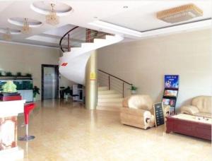 a living room with a spiral staircase in a building at JUNYI Hotel Jiangsu Wuxi Yixing Guibin Avenue in Yixing