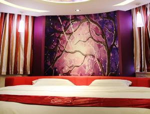 Bett in einem Zimmer mit Wandgemälde in der Unterkunft Thank Inn Chain Hotel Jiangsu Huaian Lianshui Dongding in Paifang