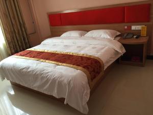 a large bed with a red headboard in a bedroom at JUNYI Hotel Shandong Zaozhuang Shanting District Xinyuan Road in Zaozhuang
