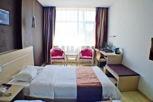 une chambre d'hôtel avec un lit, une table et des chaises dans l'établissement Thank Inn Chain Hotel Hebei Shijiazhuang Zhengding West Changshan Road, à Zhengding