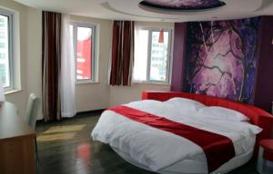 a bedroom with a red and white bed and windows at Thank Inn Chain Hotel Jiangsu Huaian Lianshui Dongding in Paifang