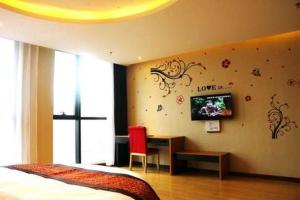 a bedroom with a bed and a desk and a tv at Thank Inn Chain Hotel Jiangsu Yancheng Dongtai Huiyin Plaza in Xintuan