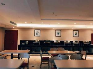 a dining room with tables and chairs and a bar at Thank Inn Chain Hotel Jiangsu Yancheng Dongtai Huiyin Plaza in Xintuan